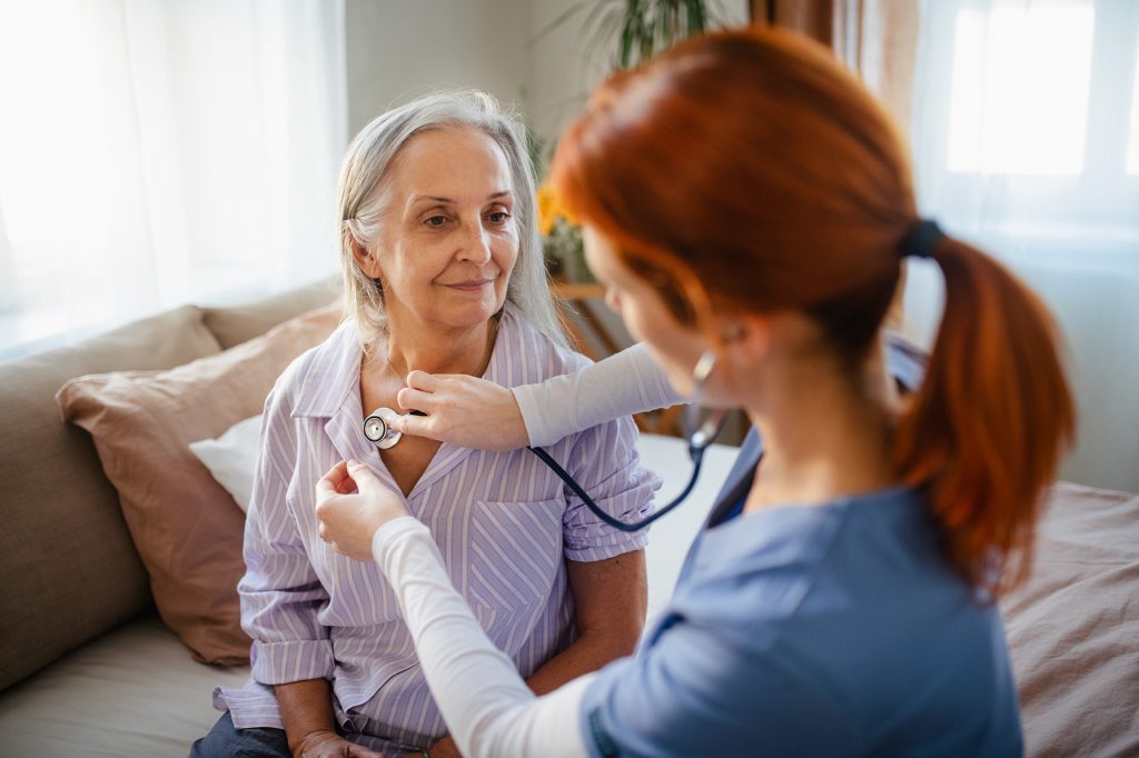 A nurse checks her patient’s breathing.
