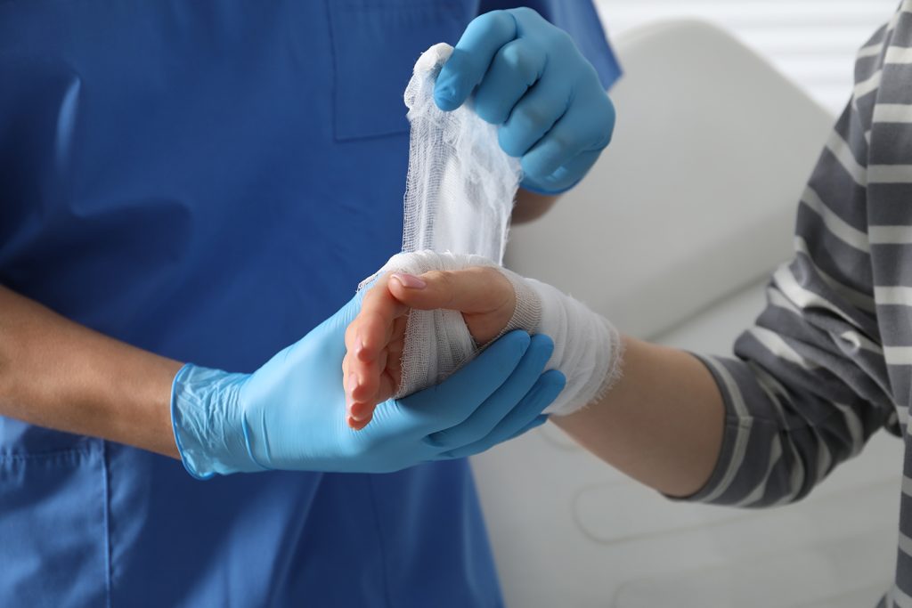 Care provider bandaging a patient’s hand at a wound care facility in Erie, PA