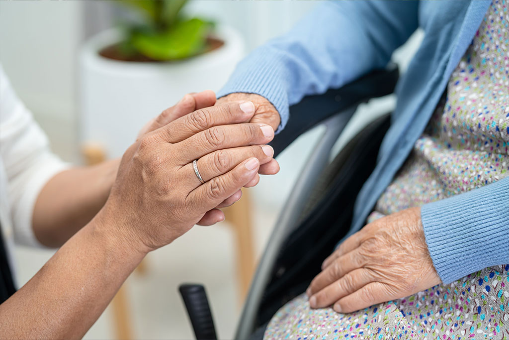 Loved one embracing hand of patient receiving best hospice care in Erie, PA